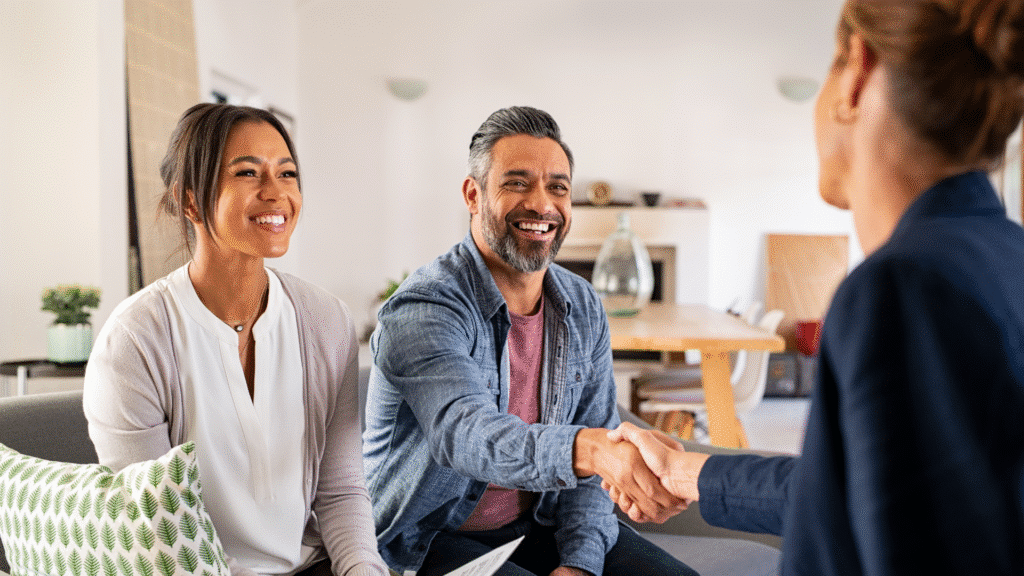 Man and woman shaking hands inside a property